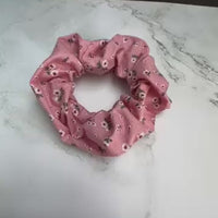 Nahaufnahme des Baumwollstoffes vom rosa Scrunchie mit kleinen Blumen – hochwertig und haarschonend