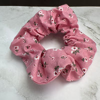Detailaufnahme des handgemachten rosa Baumwoll-Scrunchies mit floralem Muster – haarschonend und weich