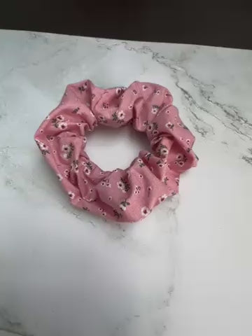 Nahaufnahme des Baumwollstoffes vom rosa Scrunchie mit kleinen Blumen – hochwertig und haarschonend